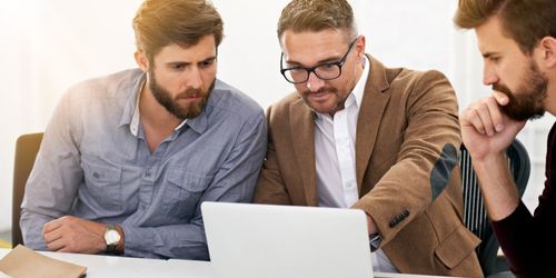 Männer beraten am Computer